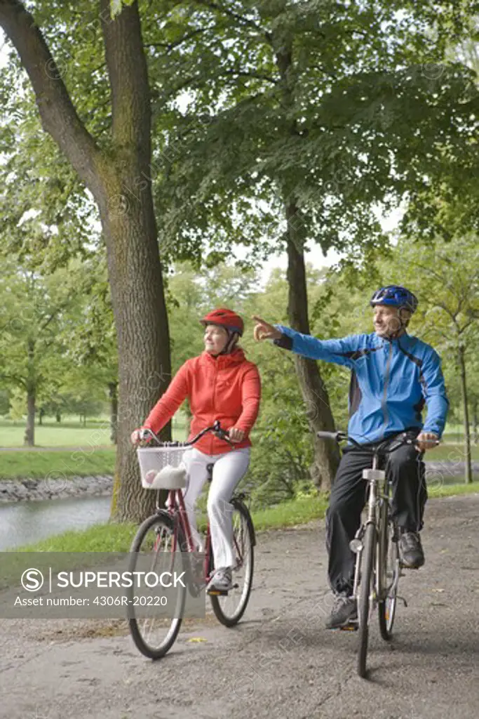 A couple cykling in a park, Sweden.