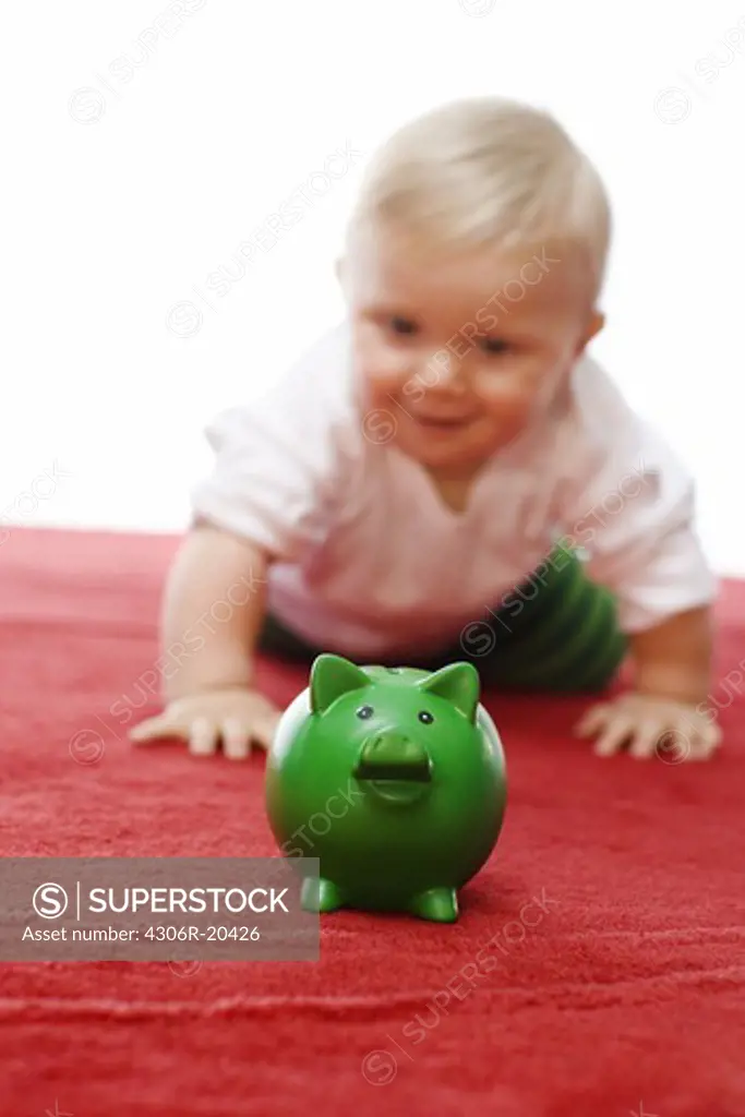 A baby with a piggy bank.