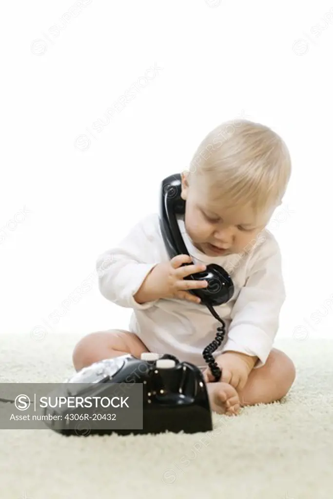 Baby playing with a telephone.