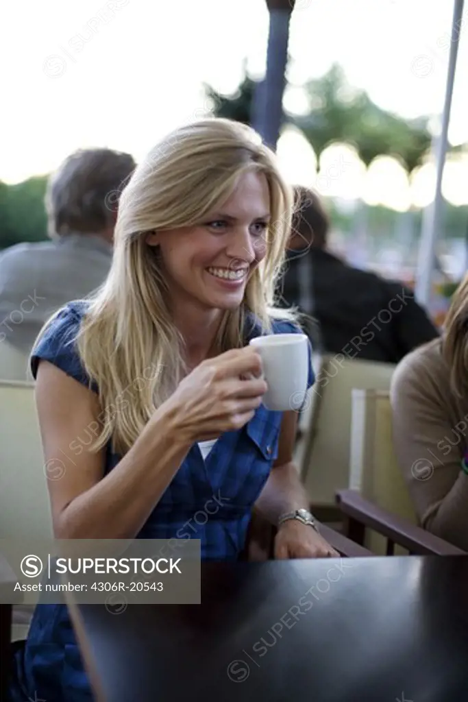 A young woman drinking a cup of coffee, Stockholm, Sweden.