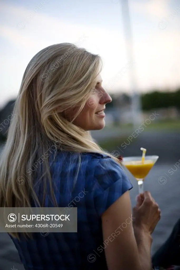 A young woman holding a drink, Stockholm, Sweden.