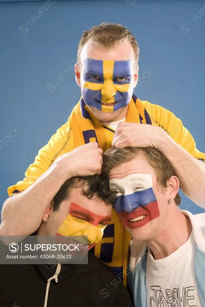 Three men with different flags painted on their faces.