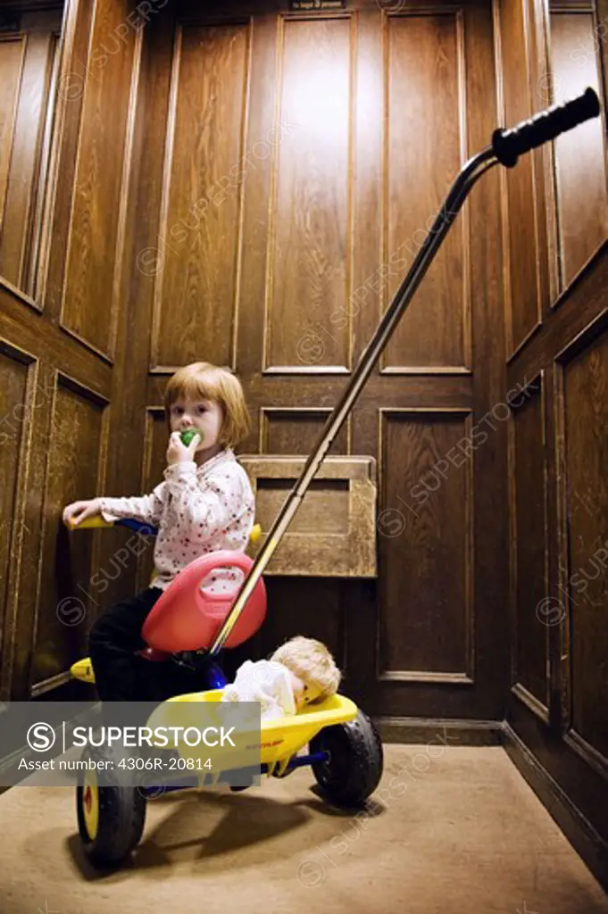 Girl on a tree-wheeler in an elevator, Sweden.