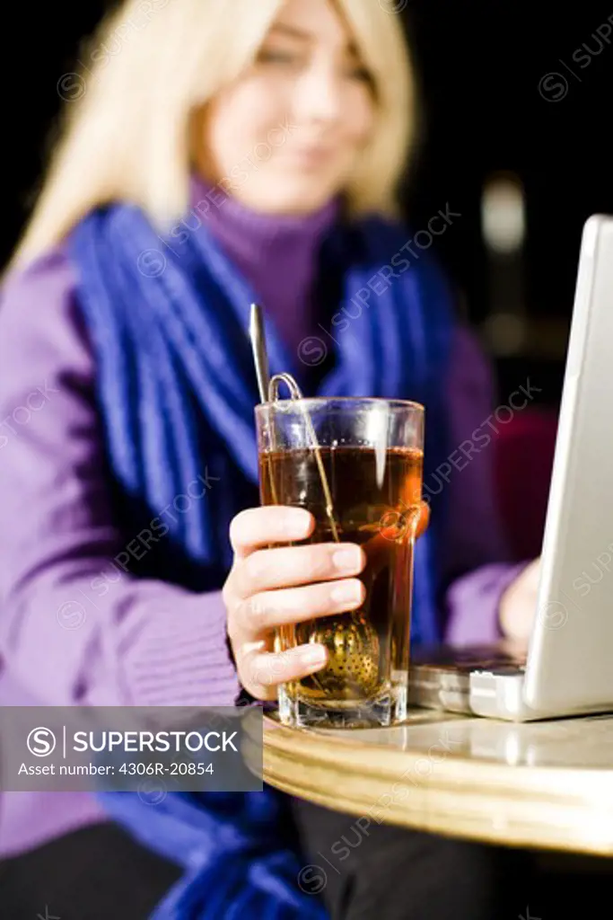 Young woman sitting in a cafe using a laptop, Sweden.