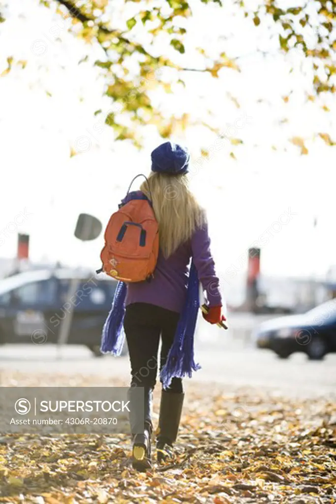 Young female student taking a walk in autumn, Stockholm, Sweden.
