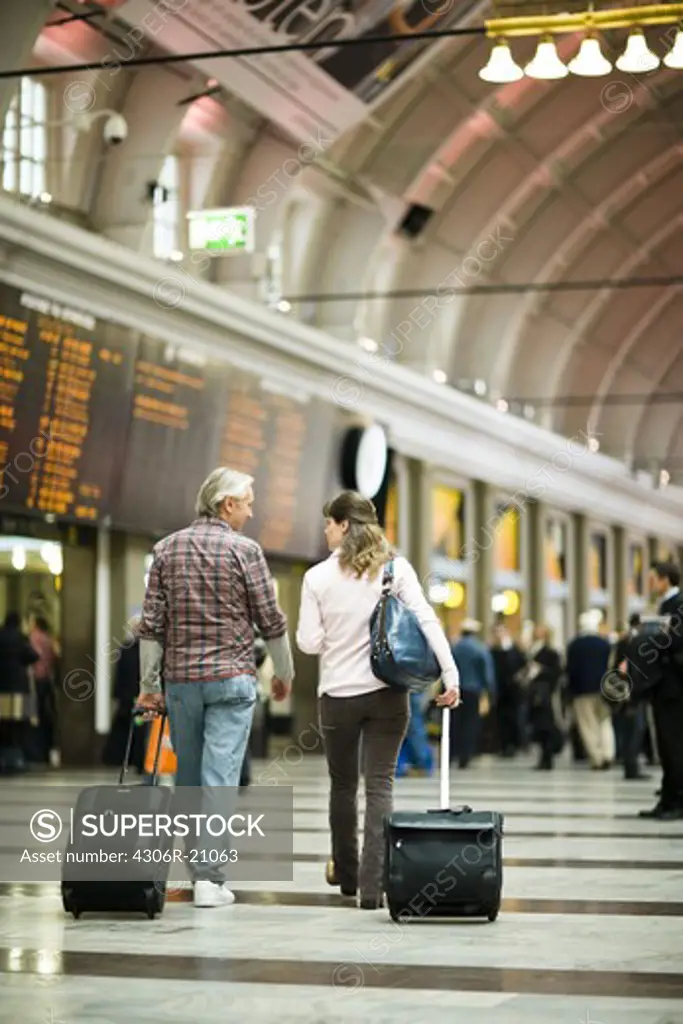 A couple with suitcases at a railway station, Sweden.