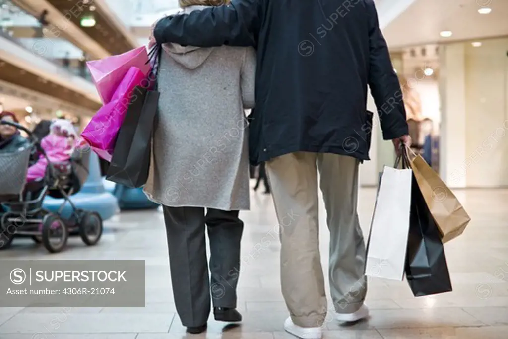 Senior couple carrying shopping bags, Stockholm, Sweden.