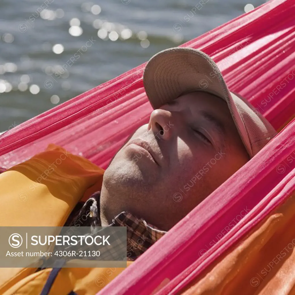 A man lying in a hammock, Sweden.