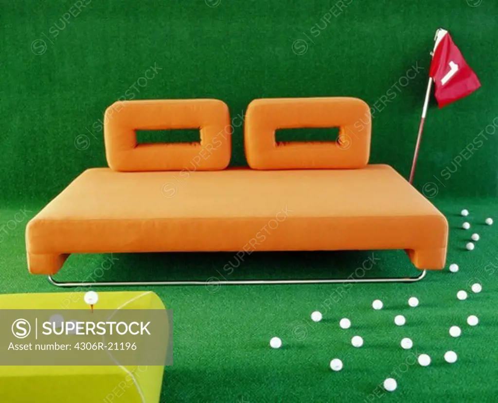 Golf balls by a couch.
