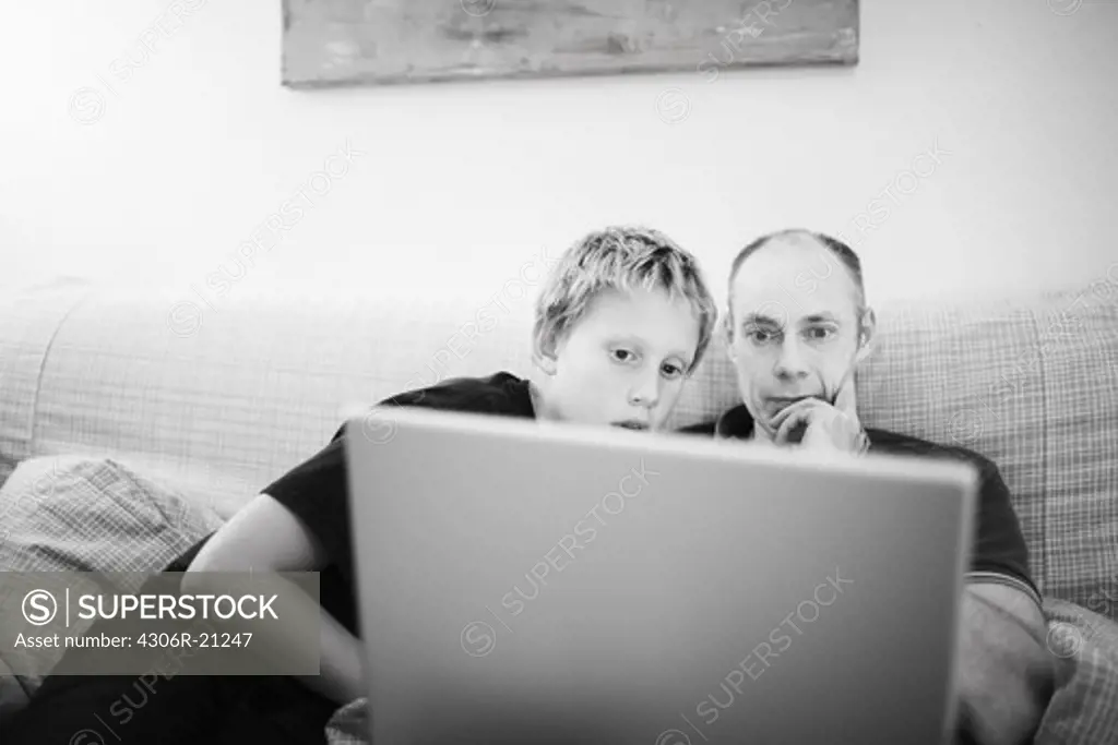 Father and son in front of a computer, Sweden.