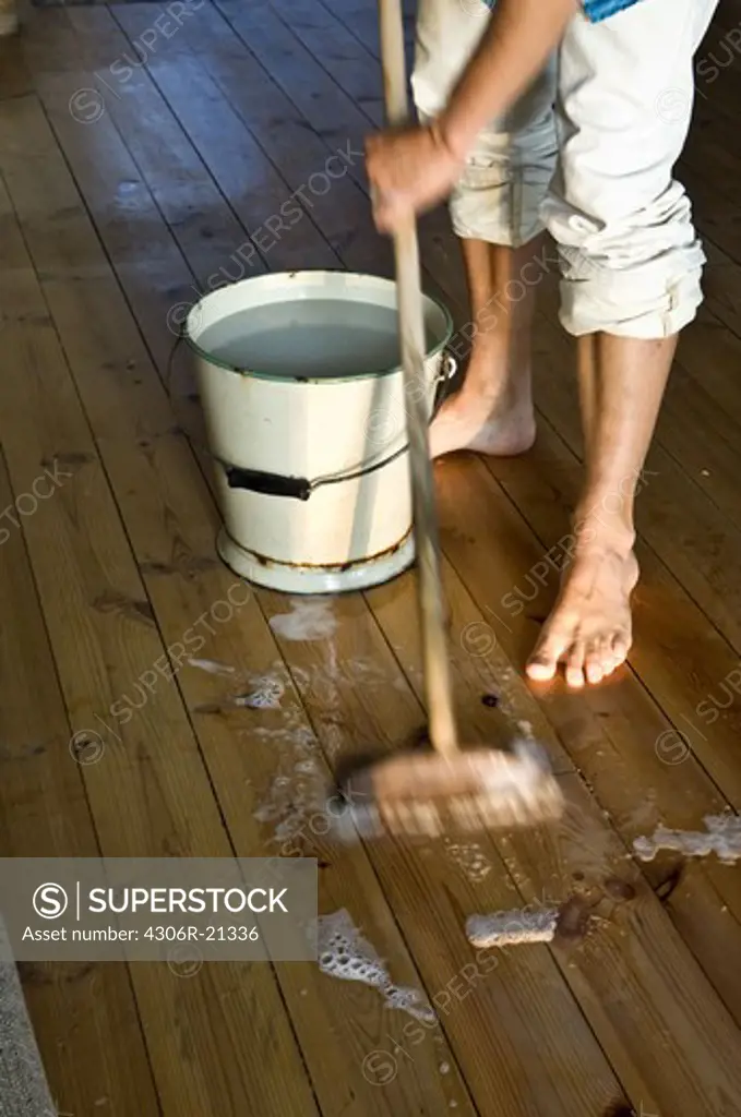 Low section of man mopping floor