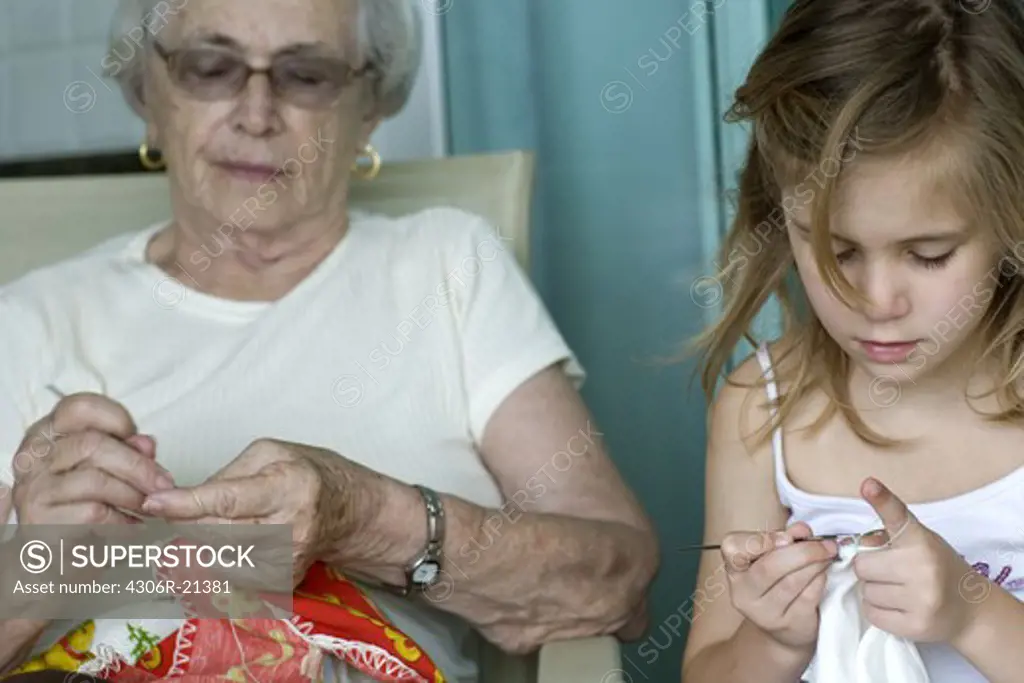 Grandmother and granddaughter crocheting, Brazil.