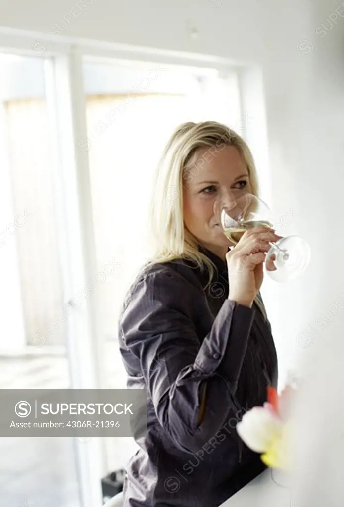 A smiling woman drinking wine, Sweden.