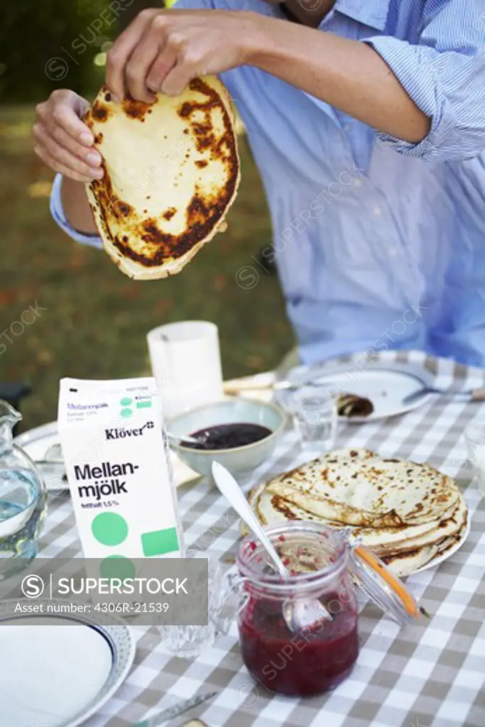 A woman holding a pancake, Sweden.