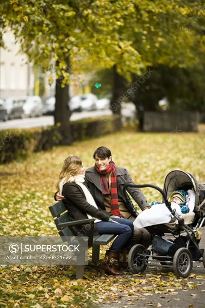 A couple siting with their son in a park, Sweden.