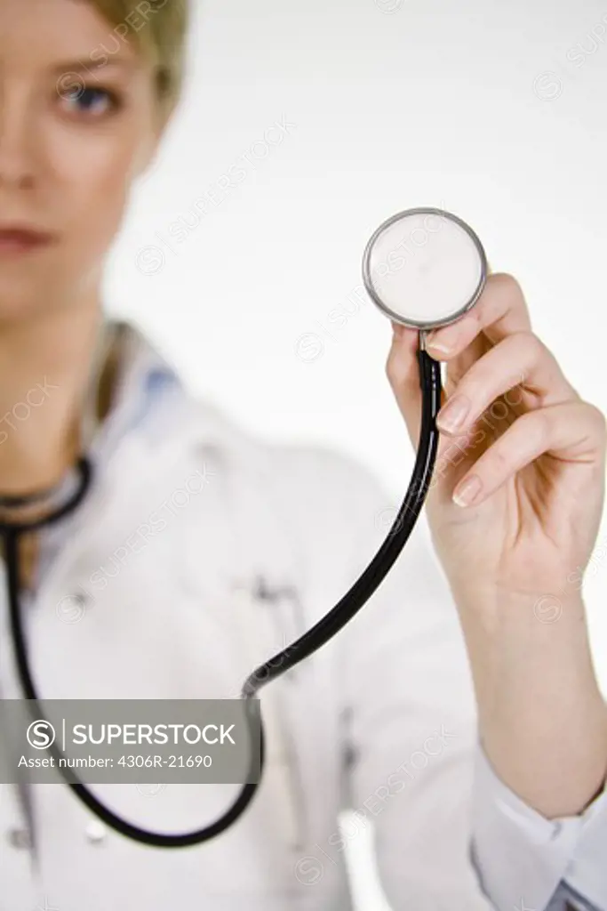 A female doctor listening into a stethoscope, Sweden.
