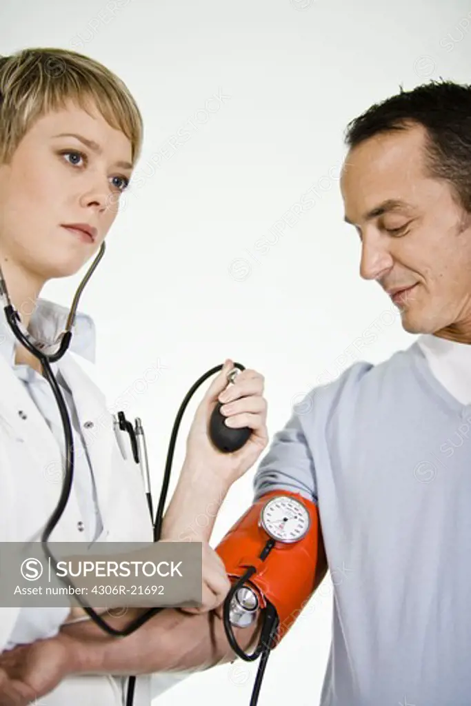 A female doctor using a blood-pressure gauge, Sweden.