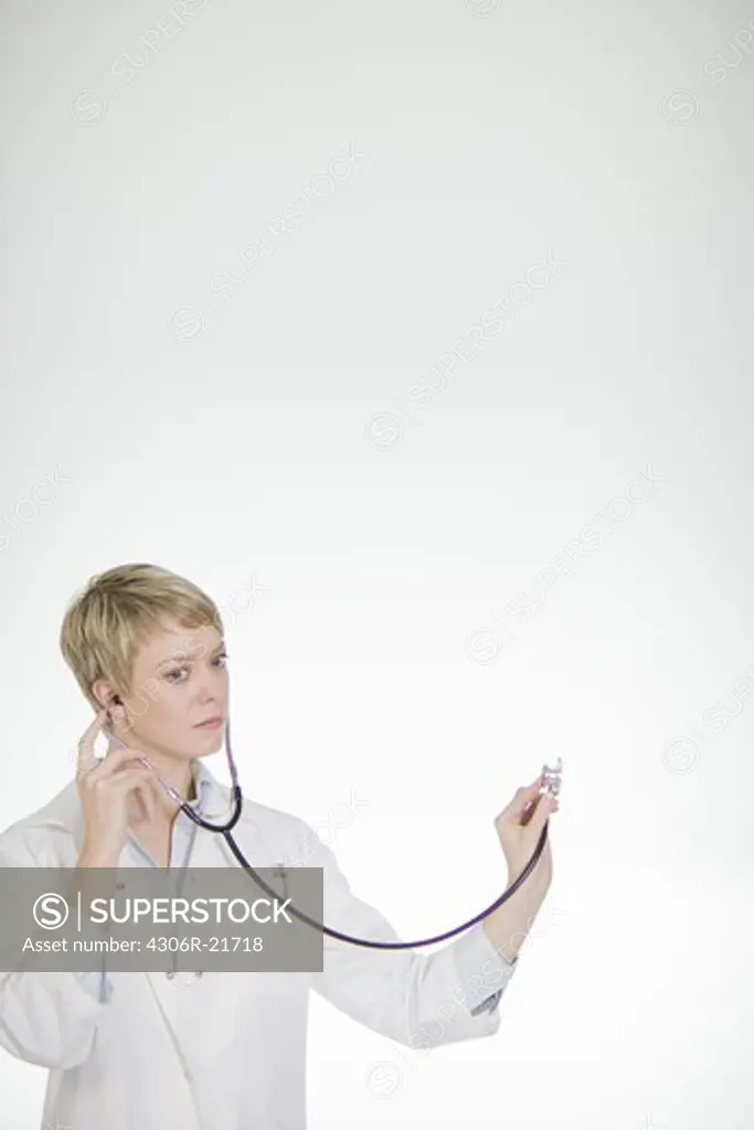 A female doctor listening into a stethoscope, Sweden.
