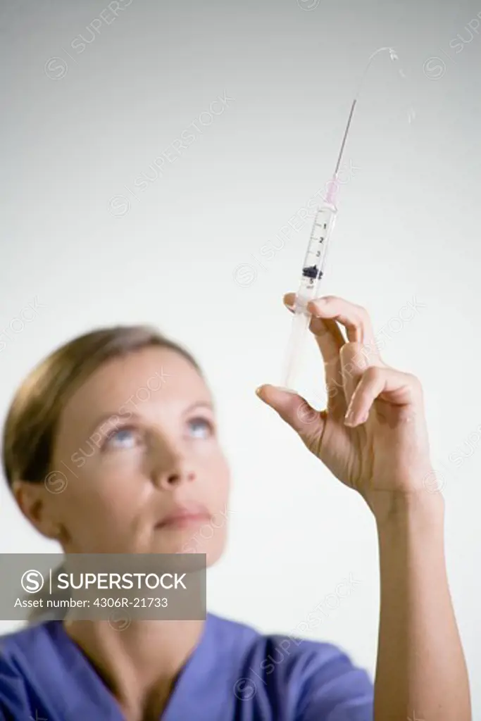 Nurse preparing injection, close-up.