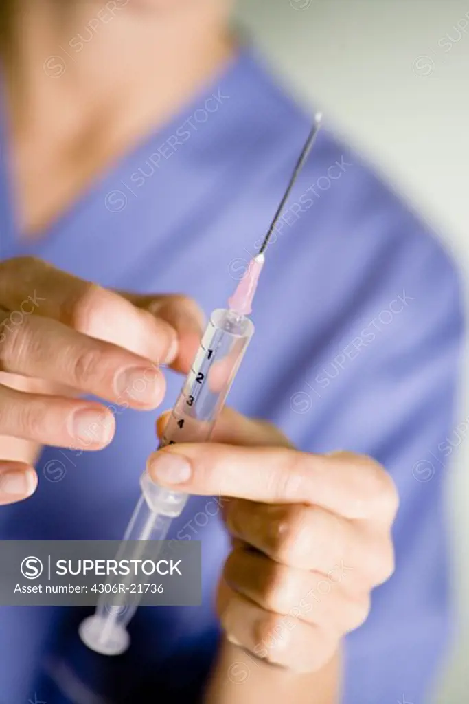 Nurse preparing injection, close-up.