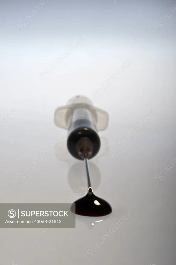 A drop of blood from a syringe.