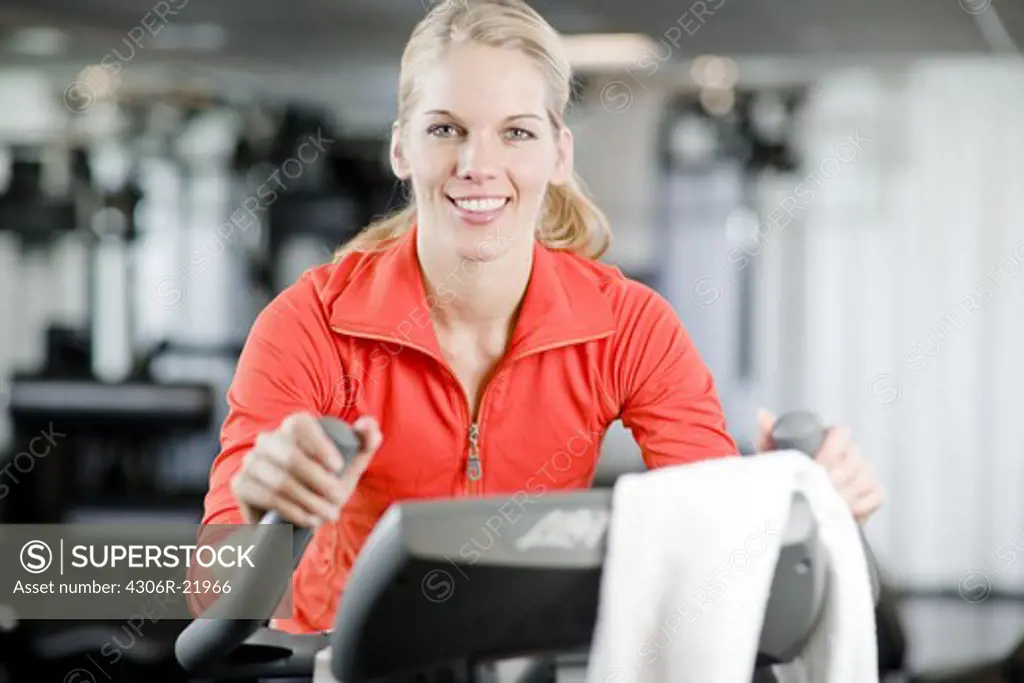 A woman doing indoor cycling at a gym, Sweden.
