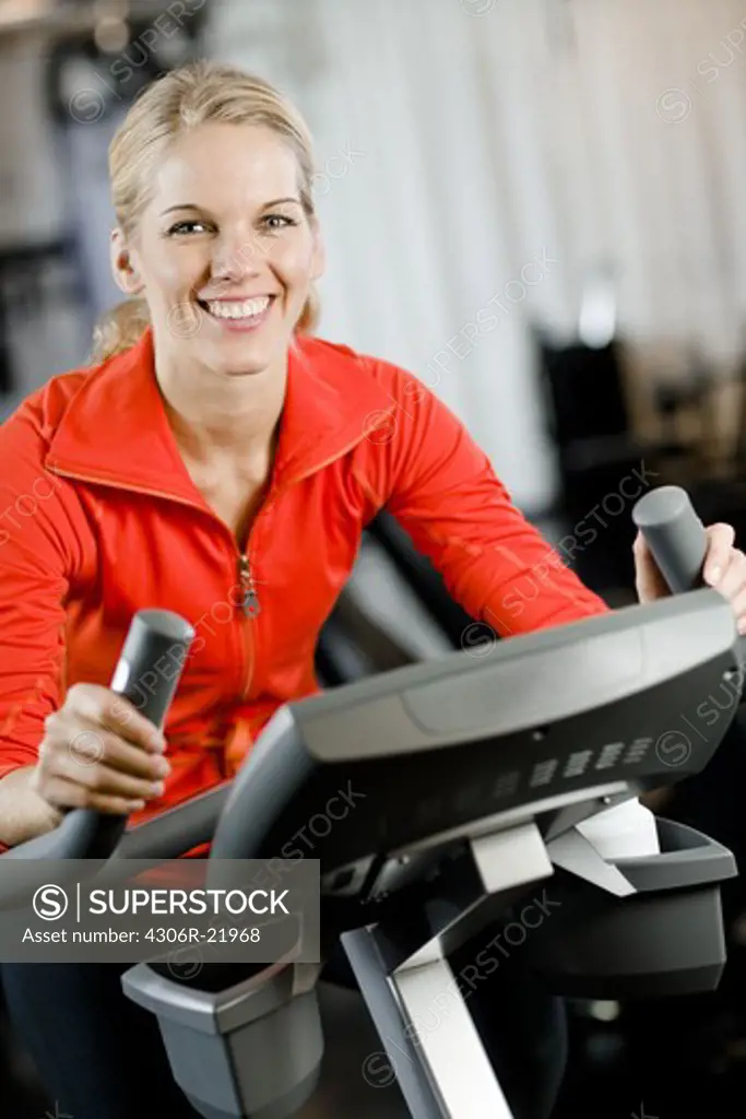 A woman doing indoor cycling at a gym, Sweden.
