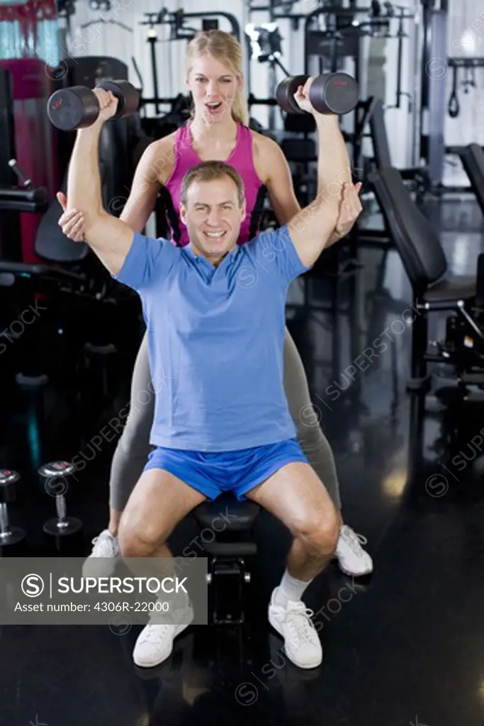A man and a woman weight training at a gym, Sweden.