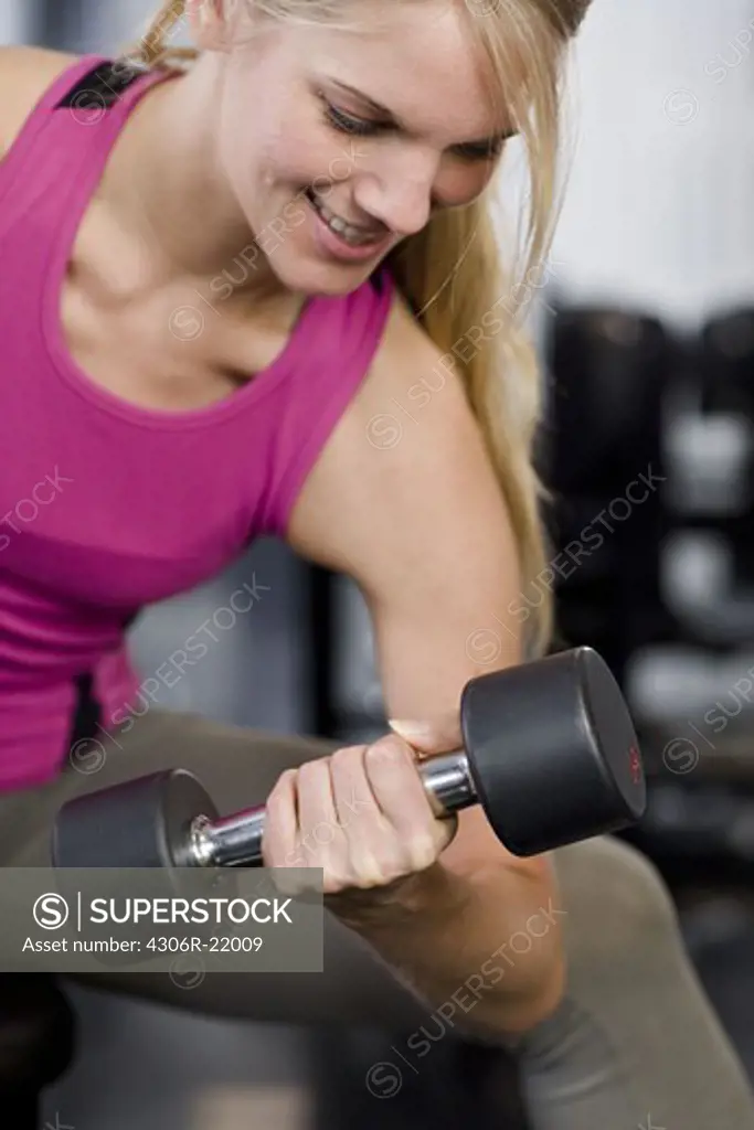 Woman weight training at a gym, Sweden.