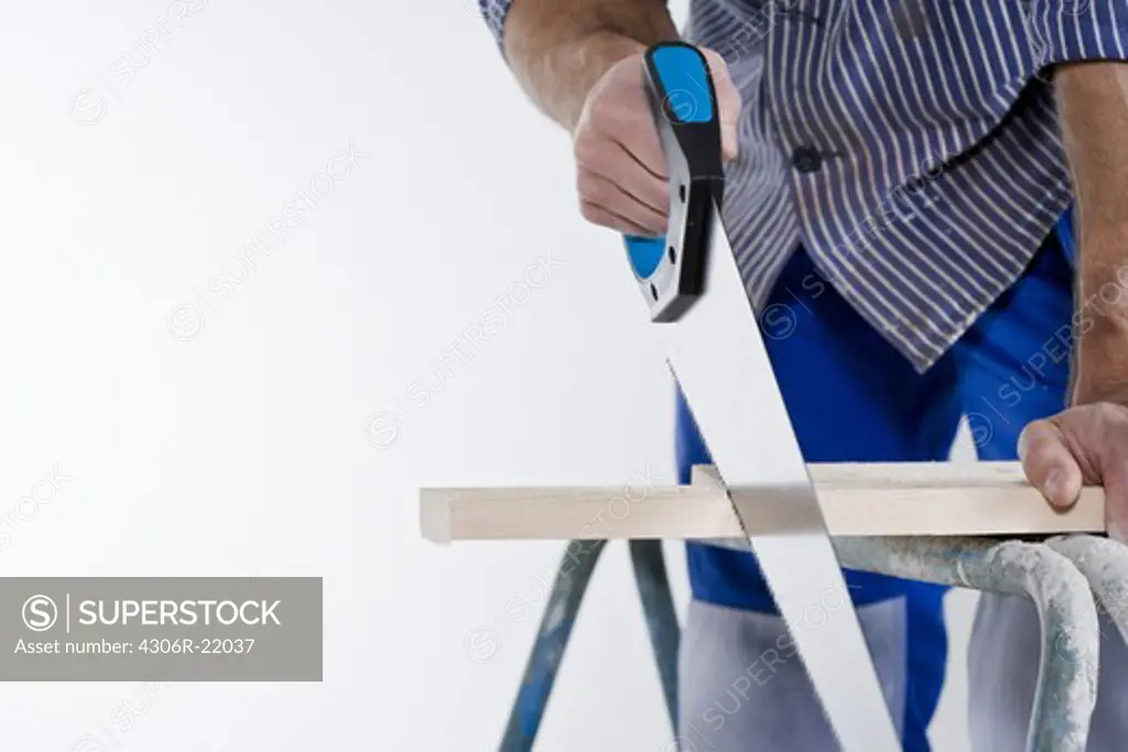 A joiner using a saw.