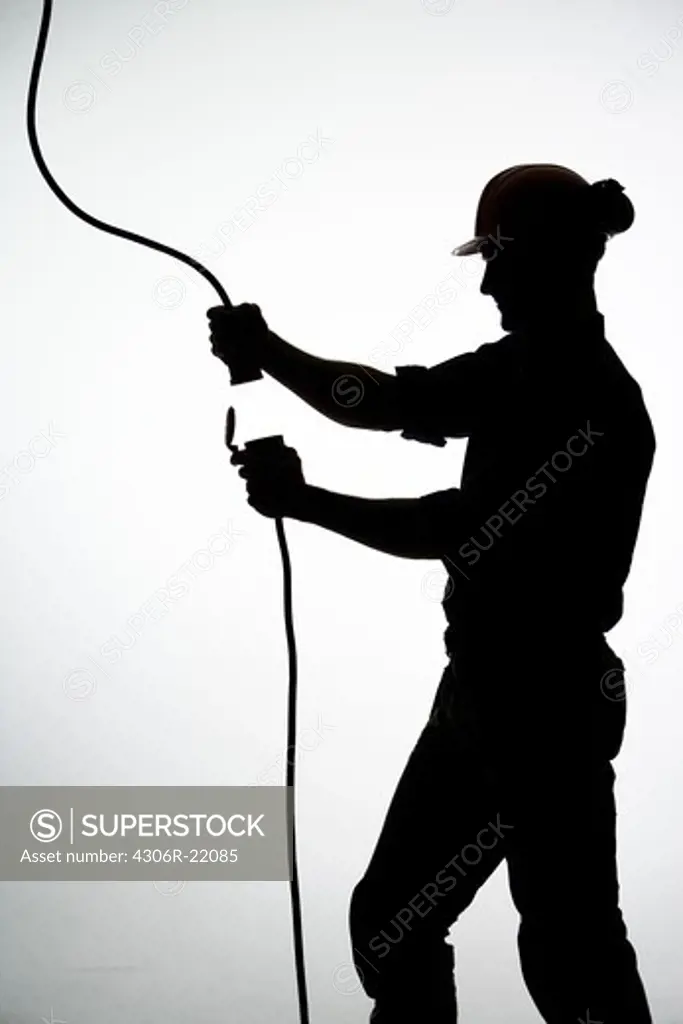 A construction worker with an electric cable.