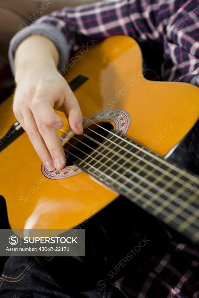 A teenager playing the guitar.