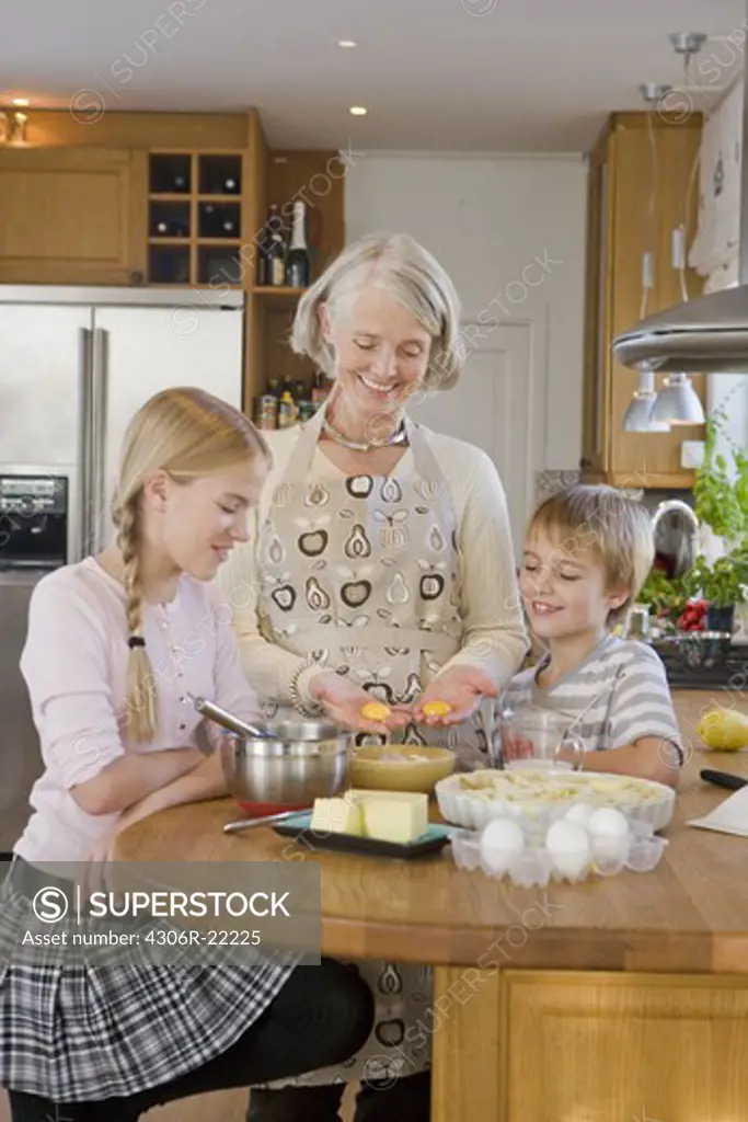 Grandchildren baking a cake with their grandmother, Sweden.