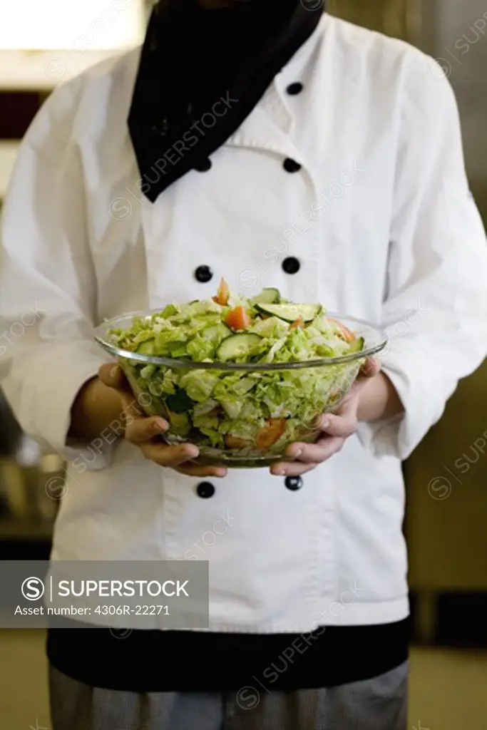 Cook holding a bowl of salad, Sweden.