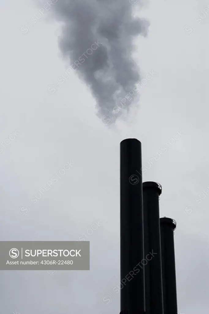 Three chimneys against a cloudy sky, Denmark.
