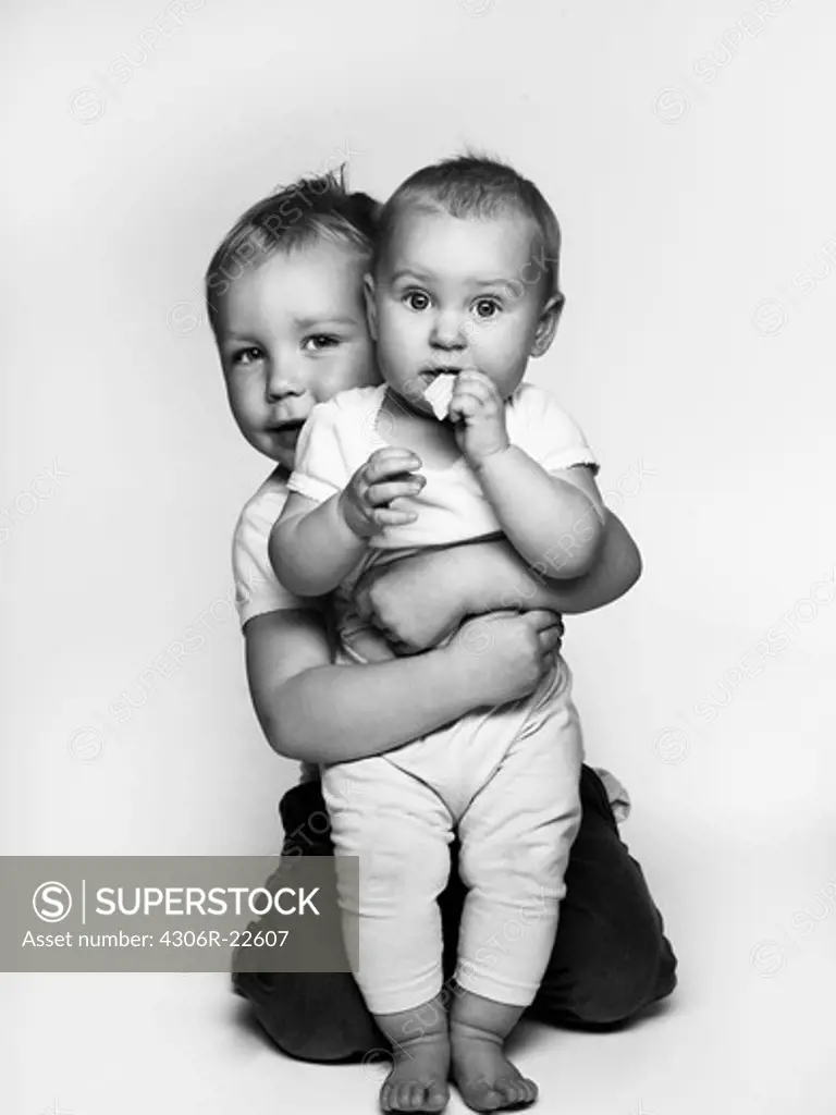 Portrait of boy embracing baby girl