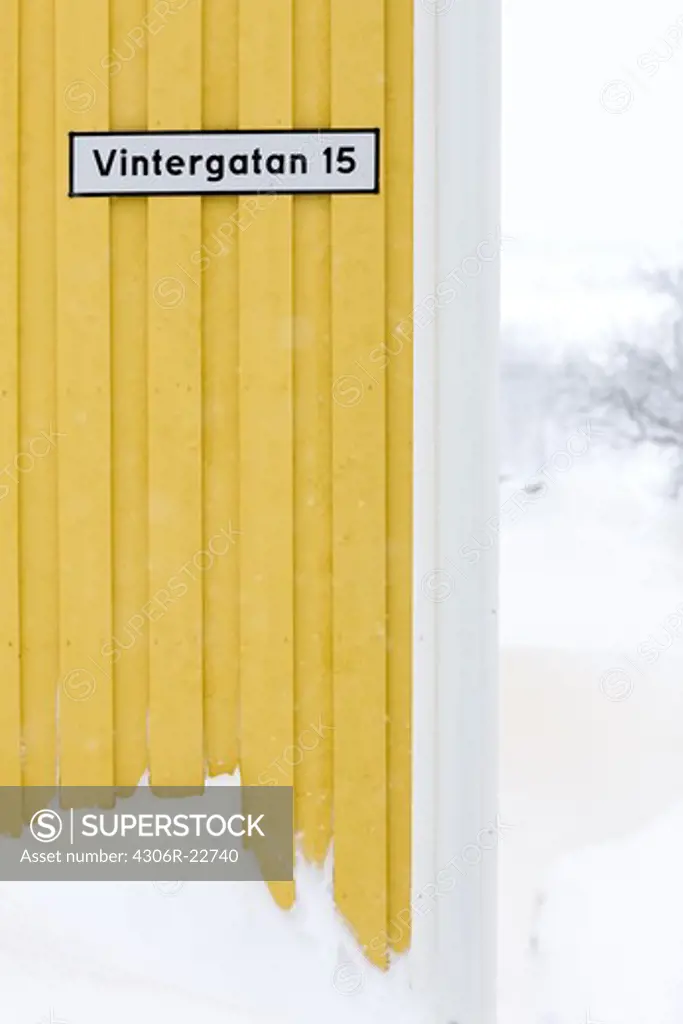 A street sign on a yellow wall, Sweden.