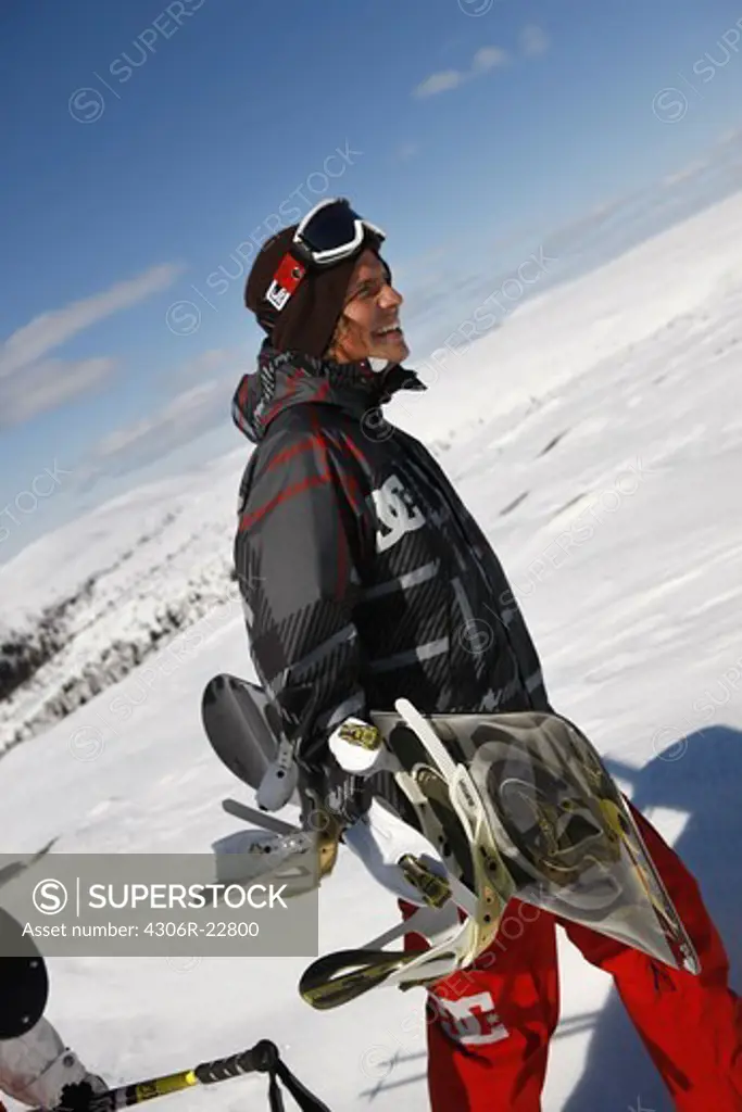 Man carrying a snowboard, Sweden.