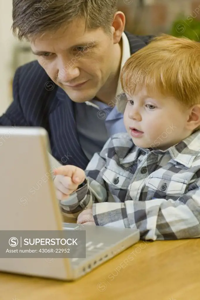 Father and son using a laptop, Sweden.