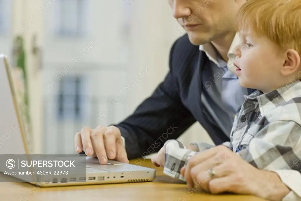 Father and son using a laptop, Sweden.
