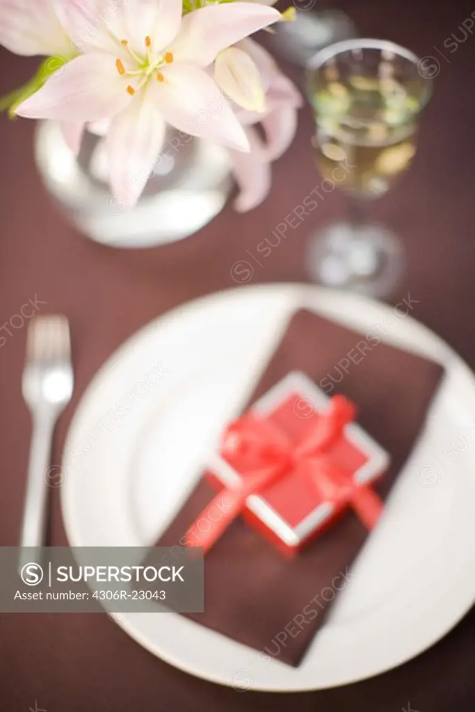 Table laid with a little red box on a plate.