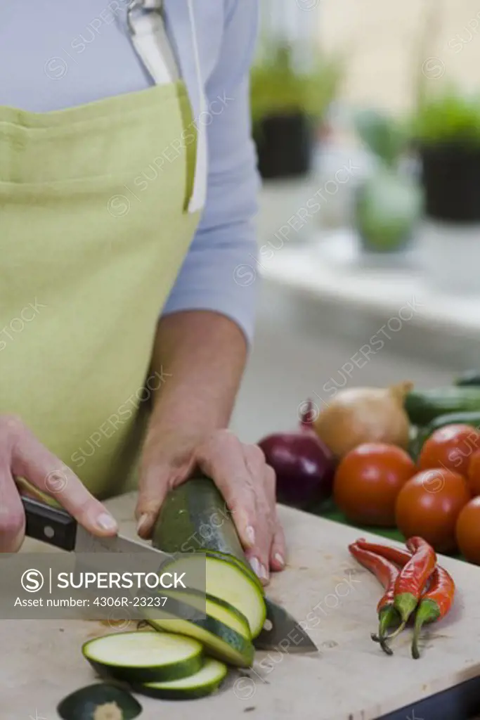 Woman cutting up vegetables, Sweden.