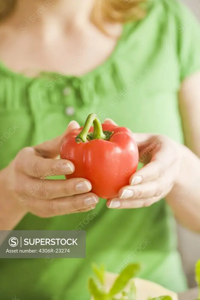 Woman holding a pepper, Sweden.