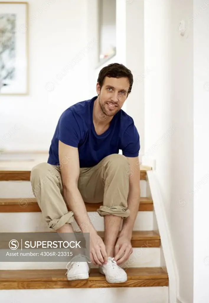 Portrait of mid adult man sitting on steps
