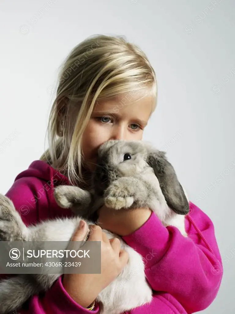 Portrait of a girl with a rabbit in her arms.