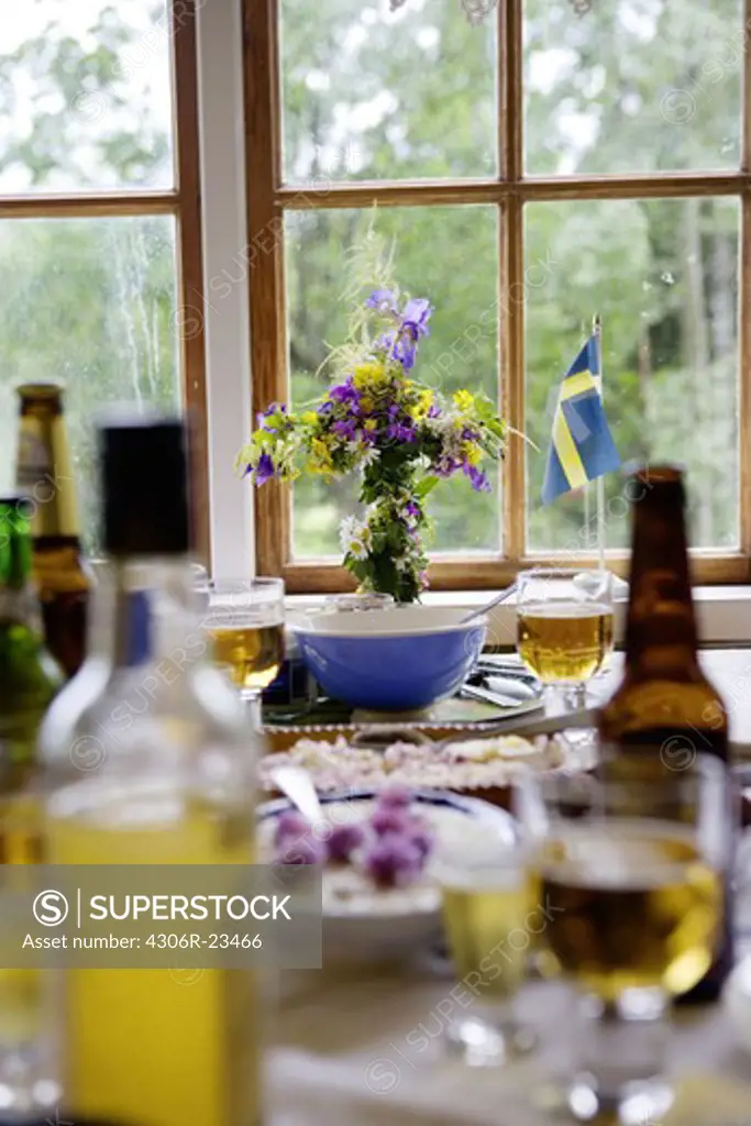 Dinner setting on table with Swedish flag and flower vase