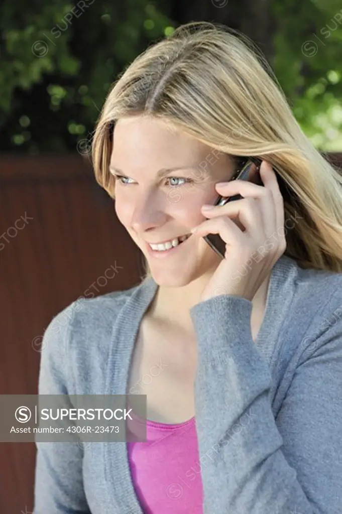 A blond woman using her mobile phone, Sweden.