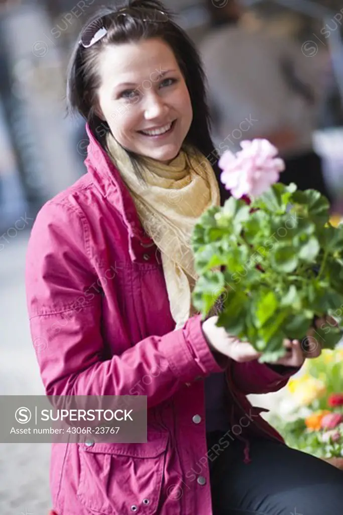 Portrait of young woman holding bunch of flowers