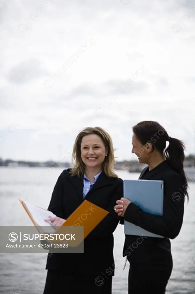 Pair of businesswoman by canal
