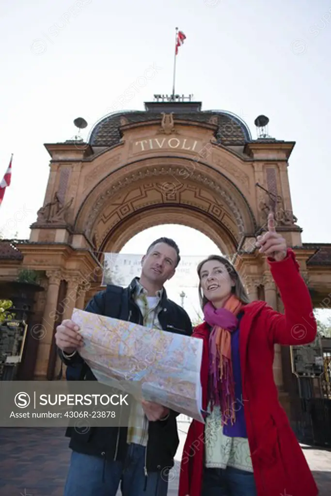 Couple with map sightseeing near arch